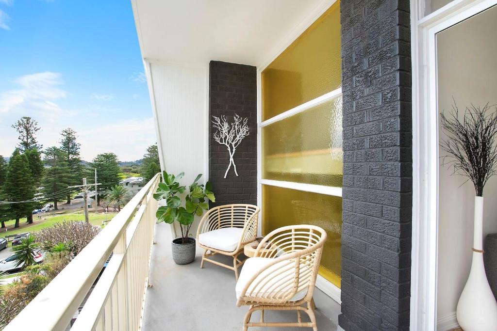 a balcony with two chairs and a window at Avalon Beachside Apartment Pool Beach Access in Avalon