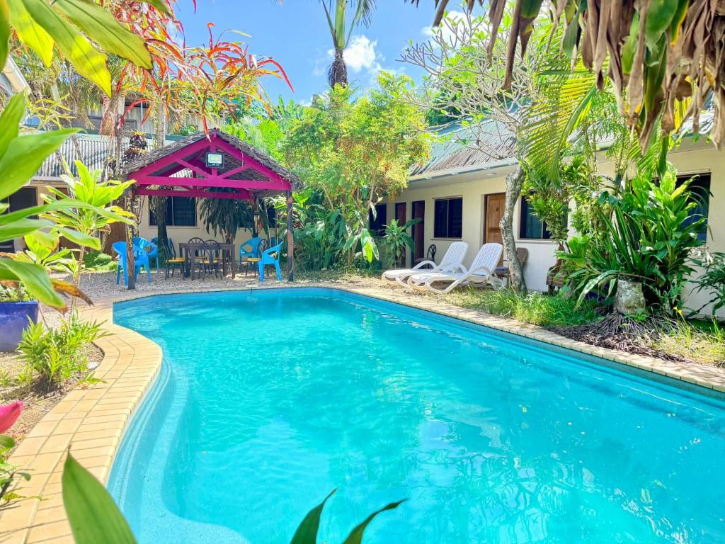 a swimming pool in front of a house at Travellers Motel Vanuatu in Port Vila