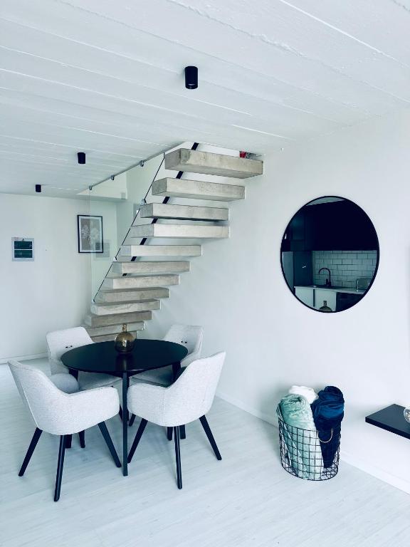 a dining room with a table and a staircase at Casa RuMat in Swakopmund