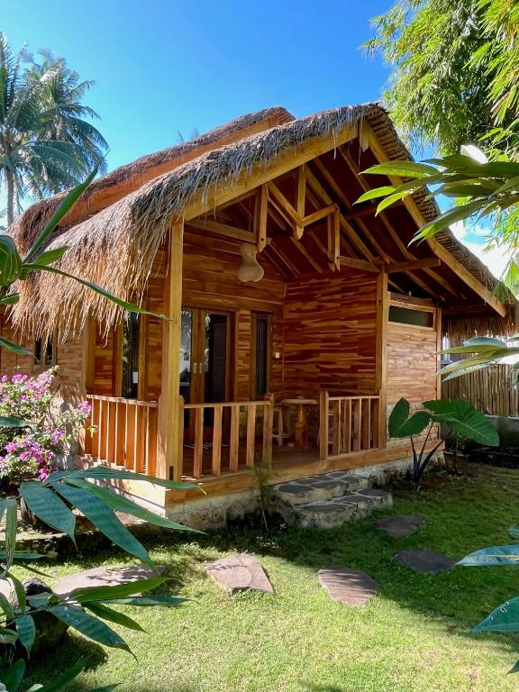 a wooden cabin with a thatched roof at Beda gaya ecolodge Rangsot 3 in Tanjung