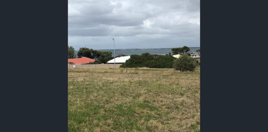 a field of grass with the ocean in the background at Seaview on Terry Court in Kingscote