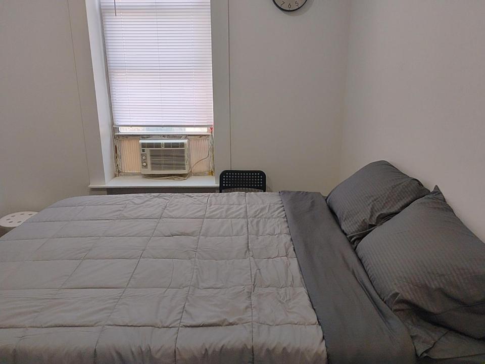 a bedroom with a large bed in front of a window at Aycee NYC Guesthouse in New York