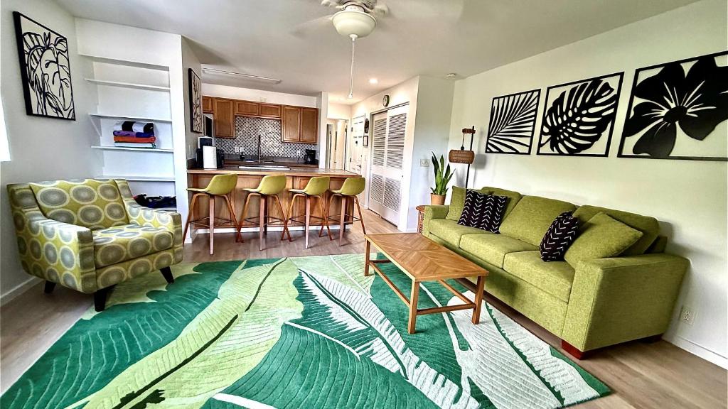 a living room with a green couch and a kitchen at Holualoa Gardens 204 in Kailua-Kona