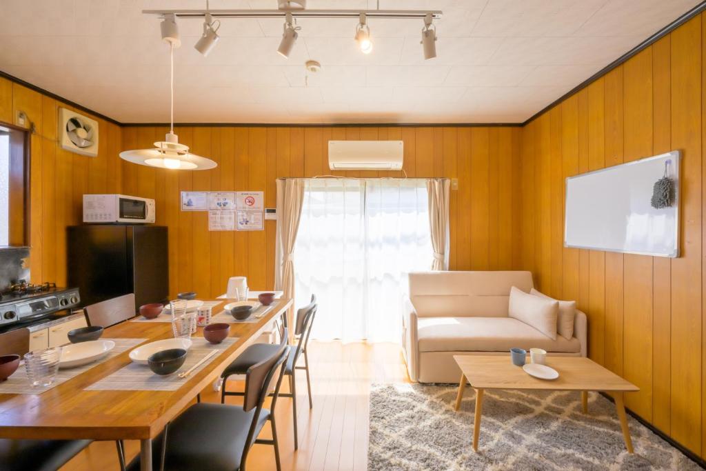 a living room with a table and a couch at もくハウス in Kamifukuoka