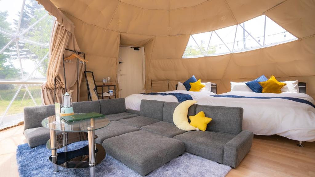 a room with two beds and a couch in a tent at yamagata glam in Murayama