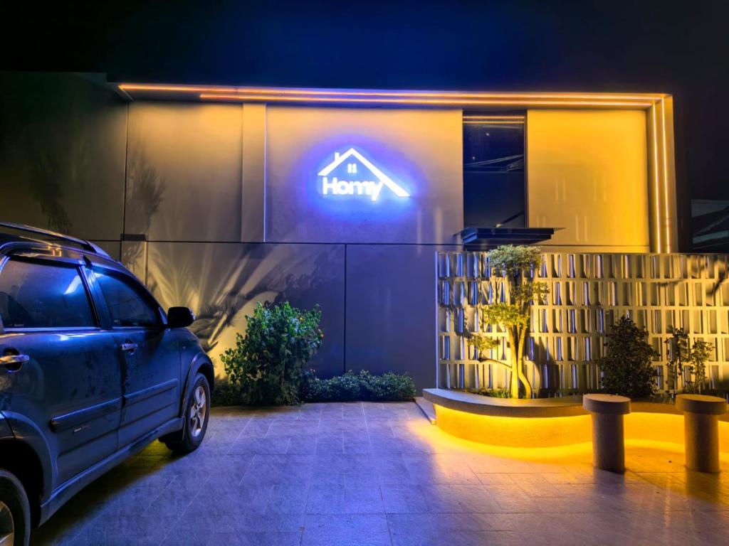 a car parked in front of a happy sign on a building at HOMY guesthouse 1 - dekat pintu TOL in Ciperna