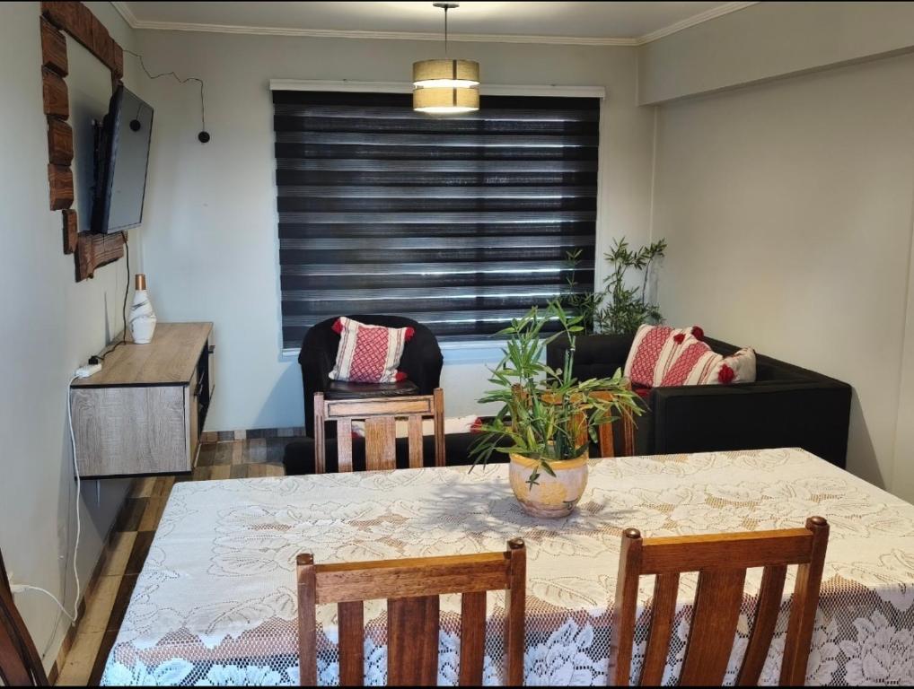 a dining room with a table and chairs and a couch at Guacolda Coquimbo in Coquimbo
