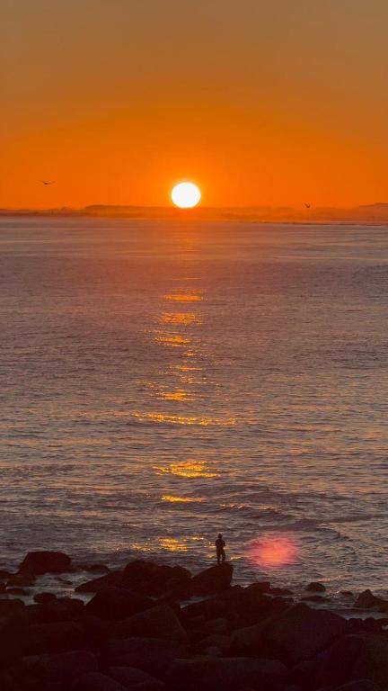 a person standing on the beach watching the sunset at Casas 2 Terrace in Laguna