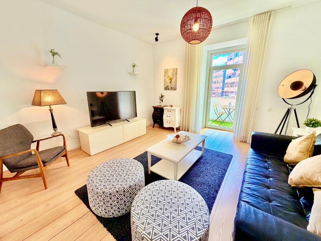 a living room with a couch and a tv at Lisboa Arroios Apartment in Lisbon