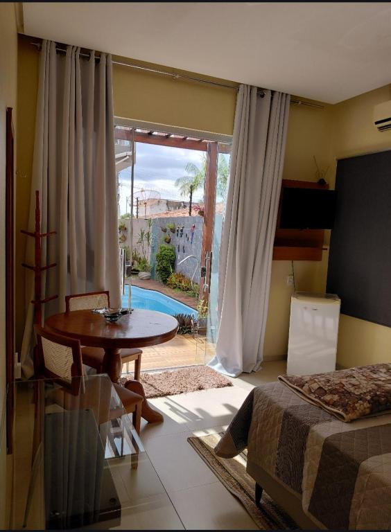 a bedroom with a bed and a table and a window at Suíte mobiliada Duo Mio in Paragominas