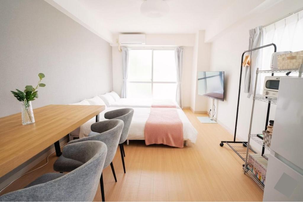 a room with a bed and a table and chairs at REKADO ROOM Shinsuizenji 3C in Kumamoto