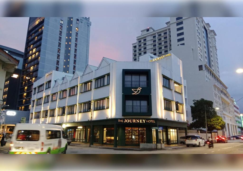 a white van parked in front of a building at The Journey Hotel Penang in George Town