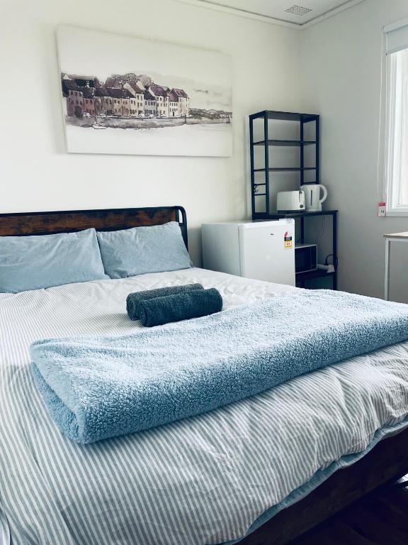 a bed with a blue blanket on top of it at Coral House in Sydney