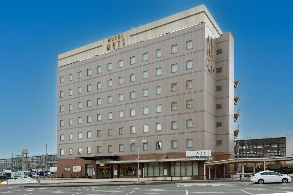 a large building with a car parked in front of it at JR-East Hotel Mets Kitakami in Kitakami