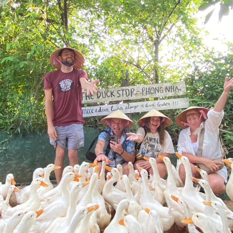 a group of people standing around a group of ducks at Phong Nha Midtown Hotel in Phong Nha