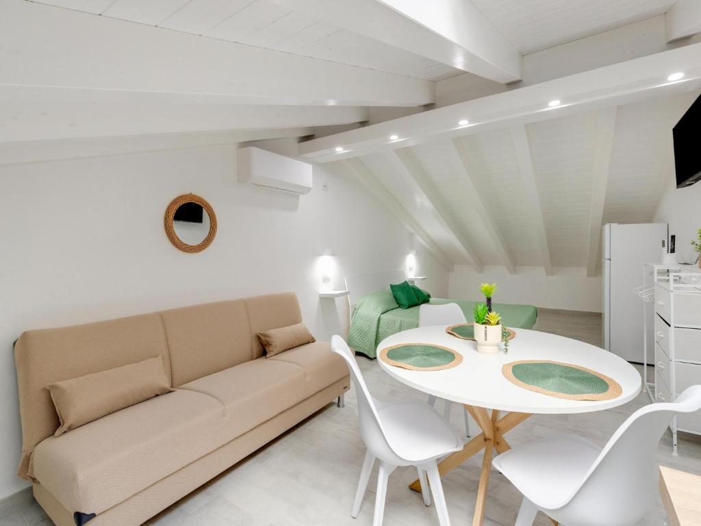 a living room with a couch and a table at Attic studio, with air conditioning in Castelsardo