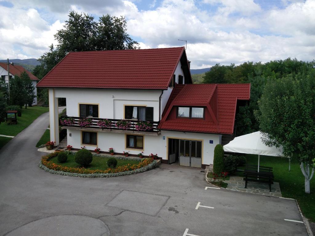 uma casa branca com um telhado vermelho em House Pavlic em Grabovac