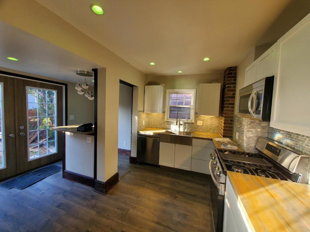 a kitchen with white cabinets and a stove top oven at Updated cozy in central Cleveland in Cleveland