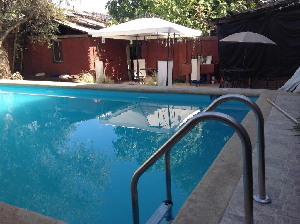 a swimming pool with a metal hand rail next to it at Hostel 1760 in Talca