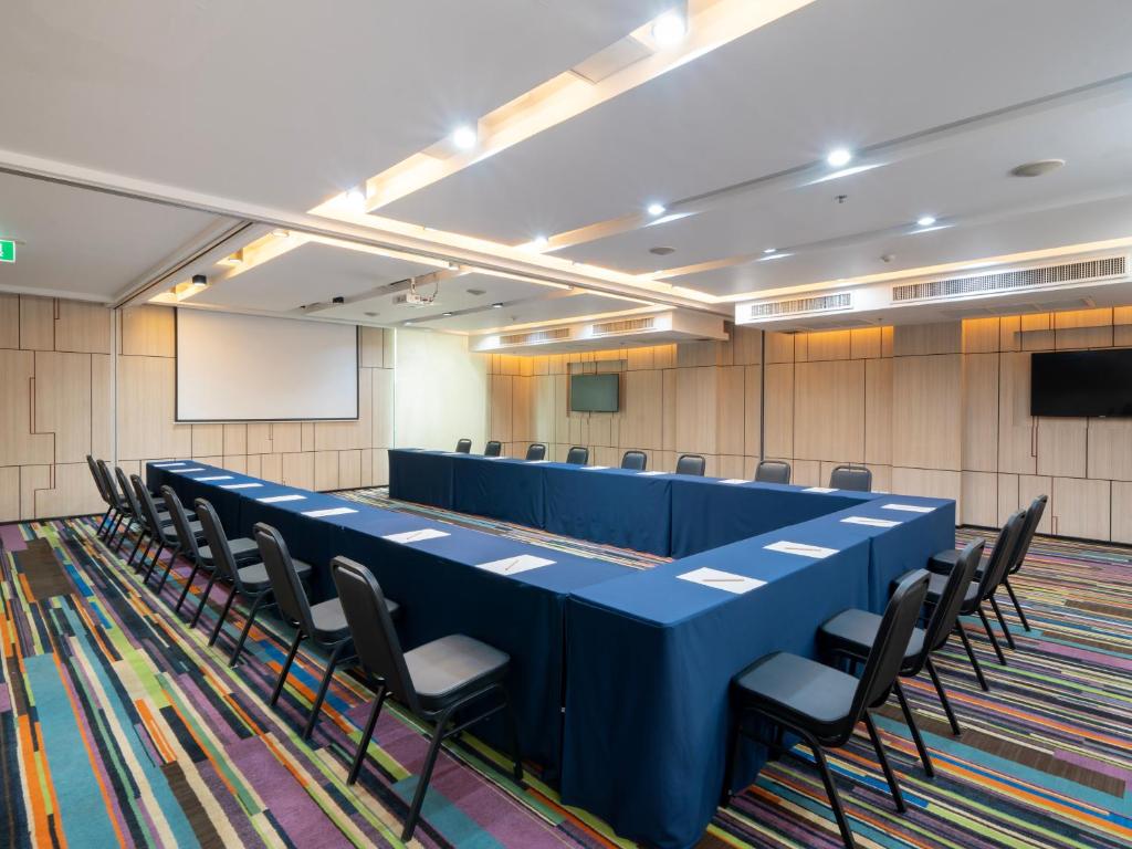A large meeting room is arranged in a U-shaped conference layout.
