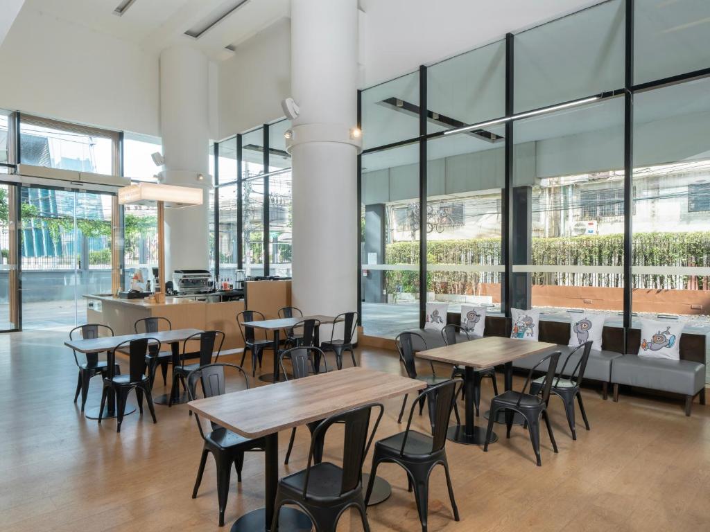 A bright dining room provides café-style tables beside floor-to-ceiling windows.