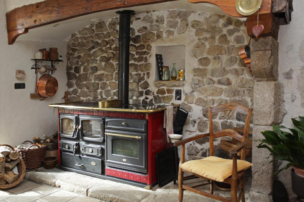 a stone kitchen with a stove and a chair at le clos saint François in Beaune-sur-Arzon