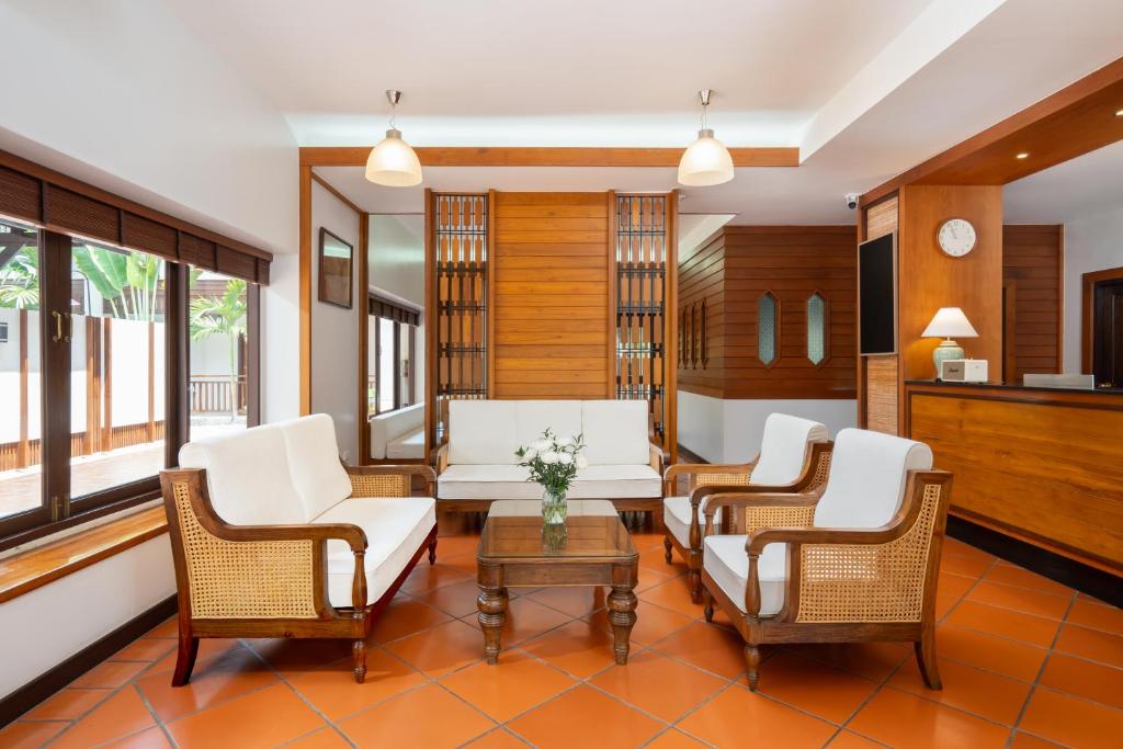 A reception lounge with rattan armchairs, a sofa and a front desk.