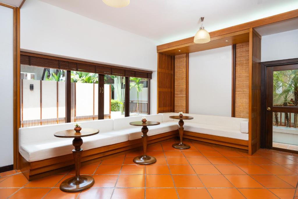 A bright sitting area with built-in benches, small tables and garden-facing windows.