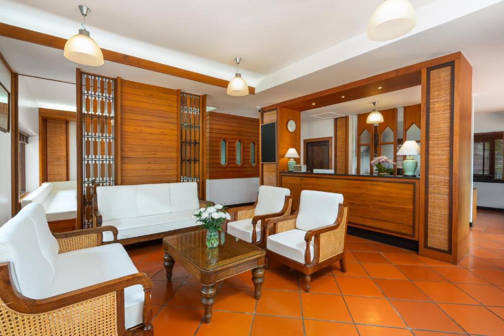 A wood-panelled lounge with white upholstered seating around a coffee table.