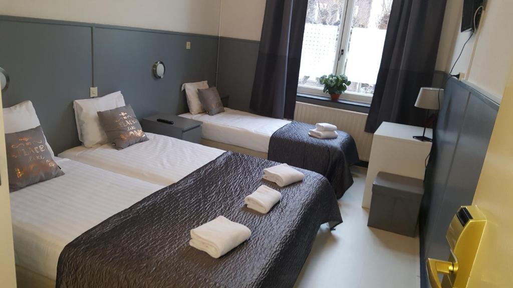 um quarto de hotel com duas camas e uma janela em Hotel Dupuis em Valkenburg