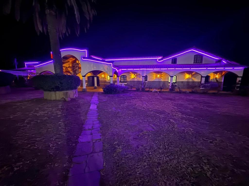 a house lit up at night with purple lights at La mansión in Salta