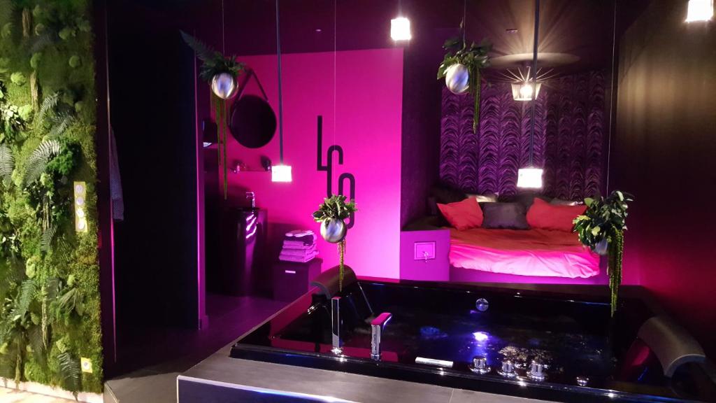 Cette chambre rose comprend un lit et un lavabo. dans l'établissement Le Clair Obscur, à Nantes
