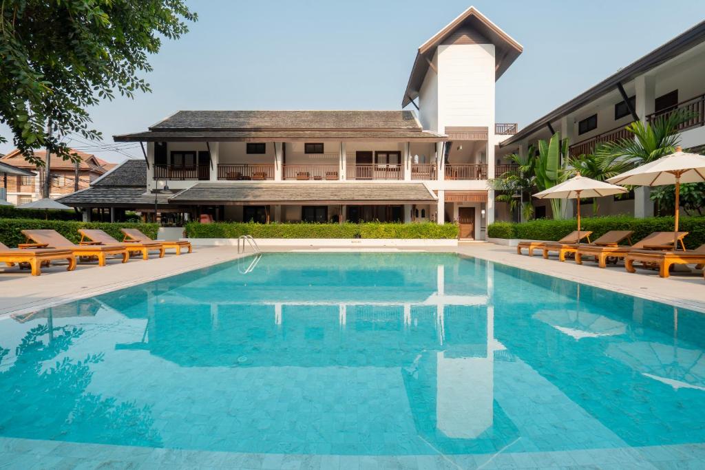 A broad turquoise pool faces the hotel’s traditional low-rise buildings.