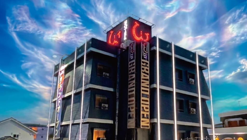 a building with a neon sign on top of it at ホテル ダブルイン茨木 in Ibaraki