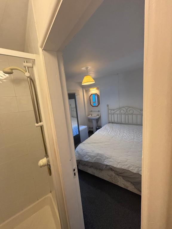 a bedroom with a white bed and a bathroom at Kinsale town centre 3 in Kinsale