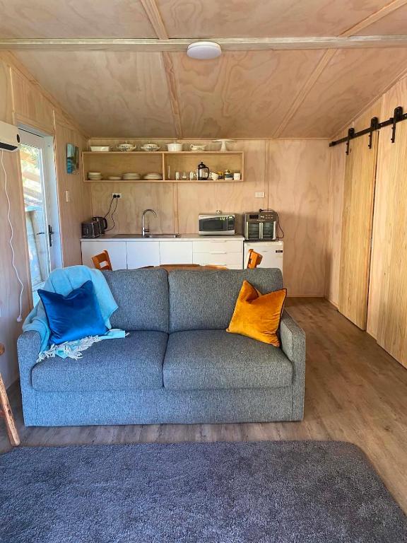 a living room with a couch in a tiny house at Hideaway Haven in Raglan