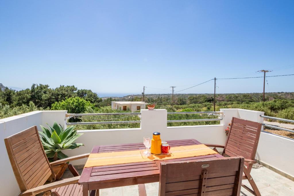 a table and chairs on the balcony of a house at Miraluna View in Mesochórion