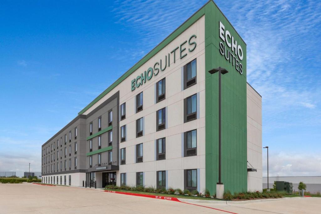 a large white and green building with a sign on it at ECHO Suites Extended Stay by Wyndham Houston Katy West in Katy