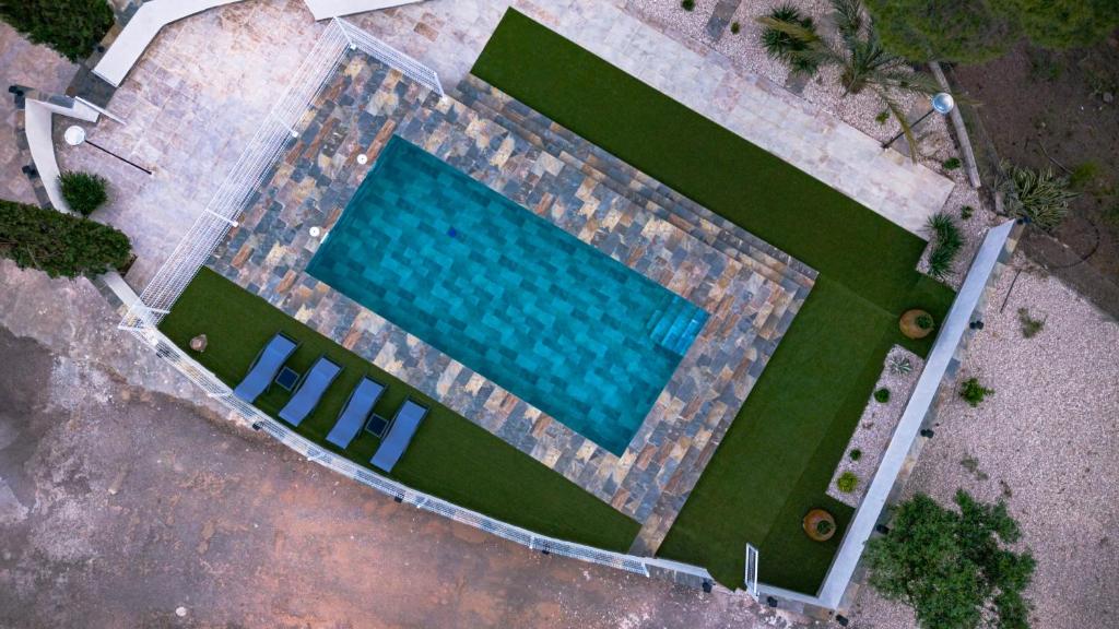 an overhead view of a swimming pool with green grass at Cortijo Cristea in Cehegín