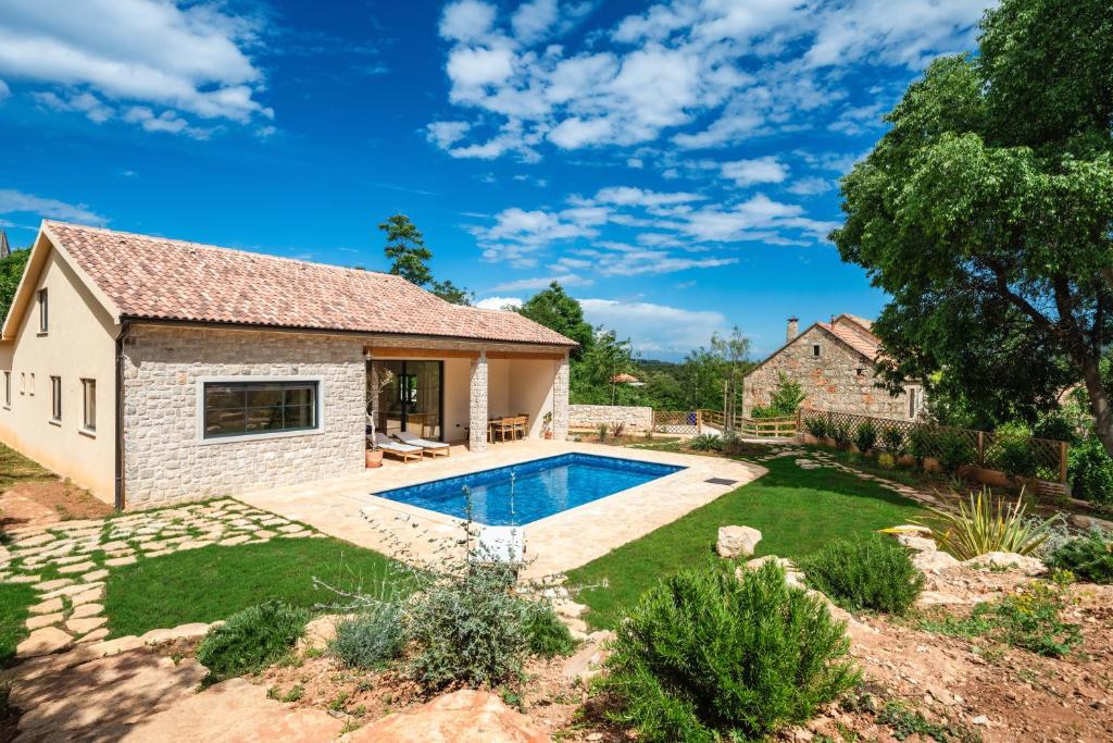 a backyard with a pool and a house at Three Little Birds in Vrbanj