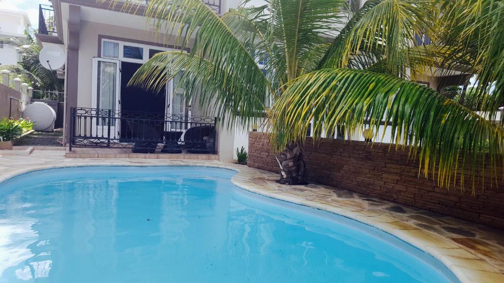 una gran piscina azul frente a una casa en Lotus Villa, en Flic en Flac