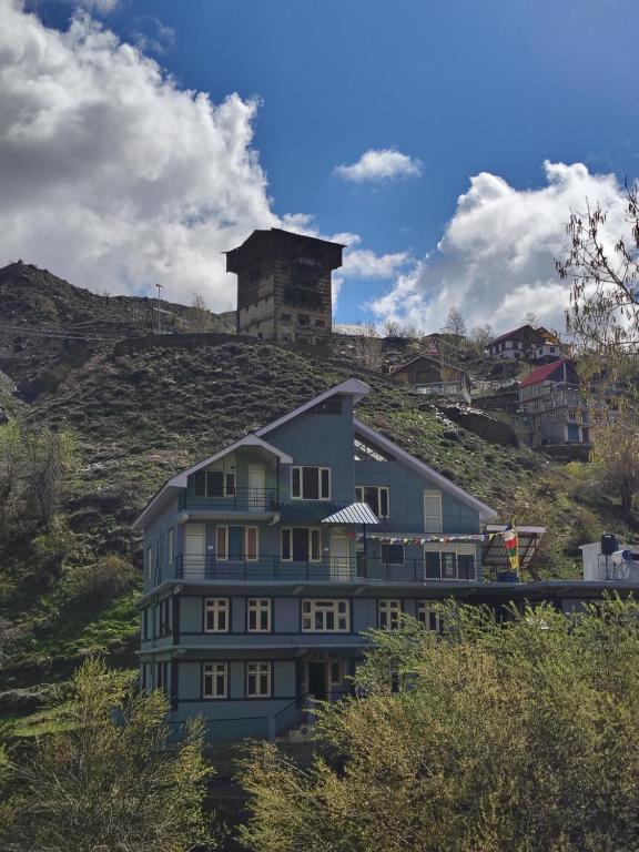 a building on a hill with a tower on top of it at beheney Homestay gondhla in Kyelang