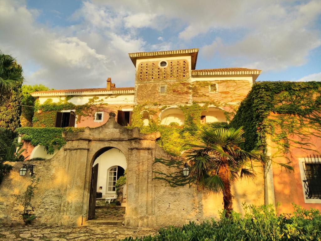サンタ・マリア・ディ・カステッラバーテにあるIl Casino Di Mare - Dimora Storicaのヤシの木が目の前に広がる古い建物