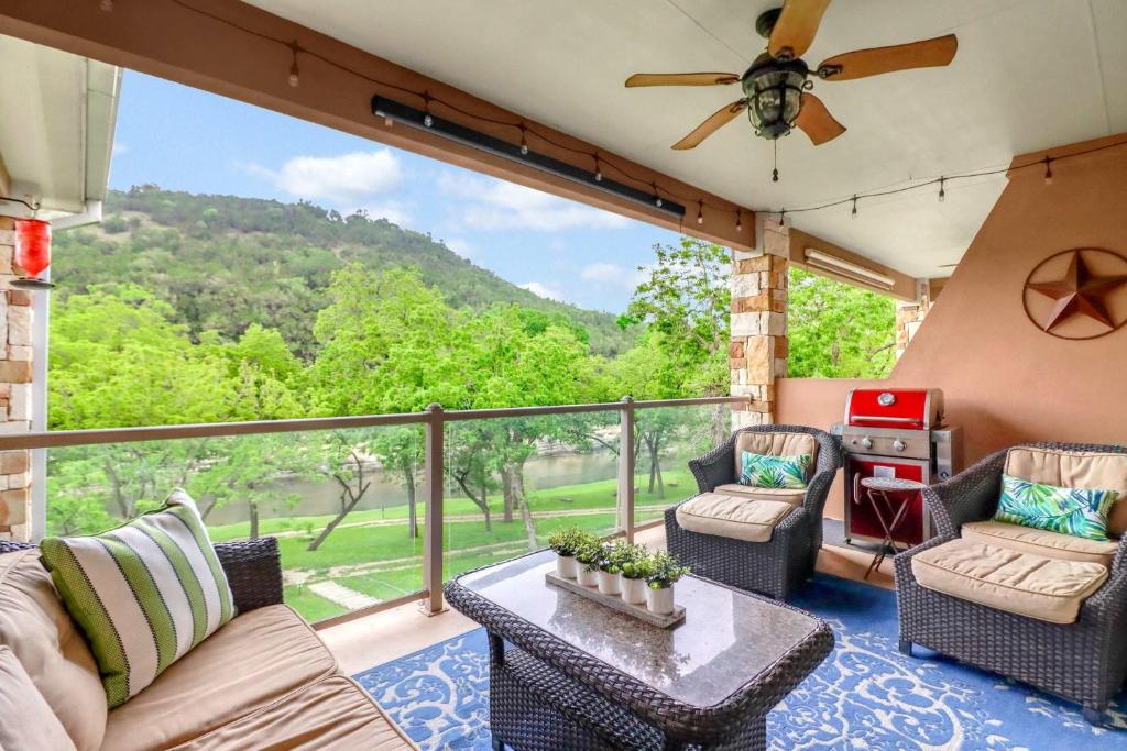 a porch with a couch and chairs and a table at Cliffside Paradise Waterfront in New Braunfels