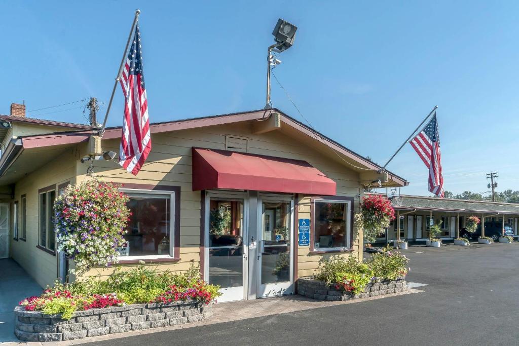 two american flags are flying outside of a store at Rodeway Inn Medford South I-5 in Medford