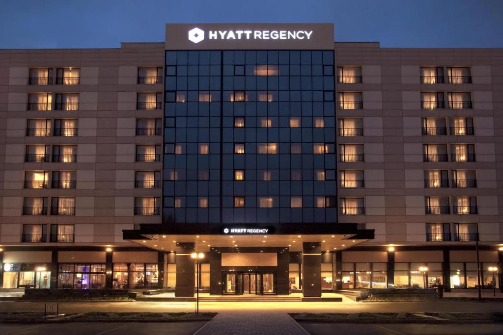 a night view of a building with a sign on it at Hyatt Regency Bishkek in Bishkek
