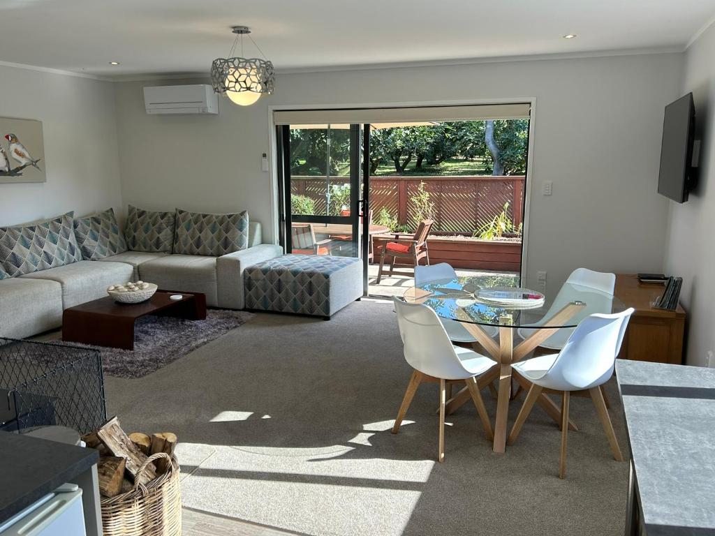 a living room with a couch and a table and chairs at Baybell Lodge in Tauranga