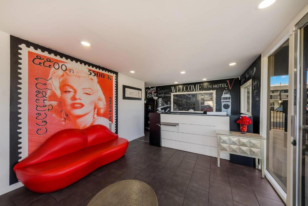 a red chair in a room with a restaurant at Rodeway Inn South San Francisco Airport in South San Francisco