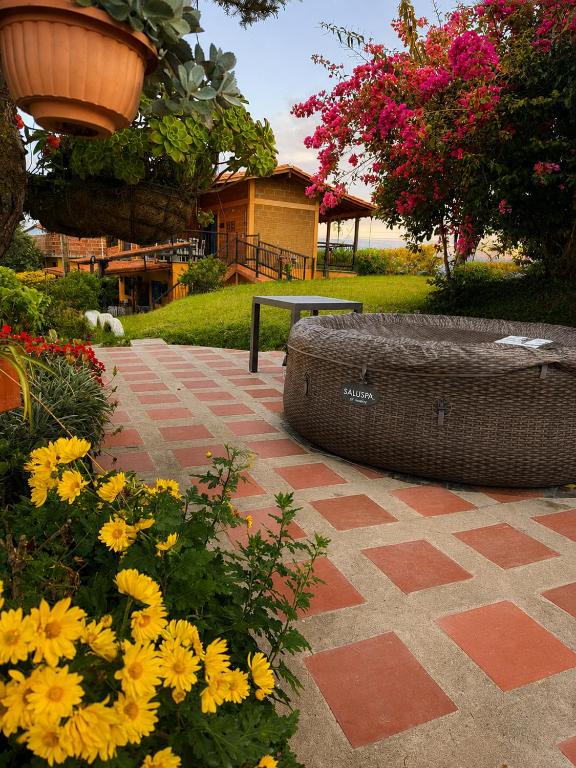 a garden with flowers and a bench in the background at Finca Cercanías Marinilla - Casa Campestre in Marinilla