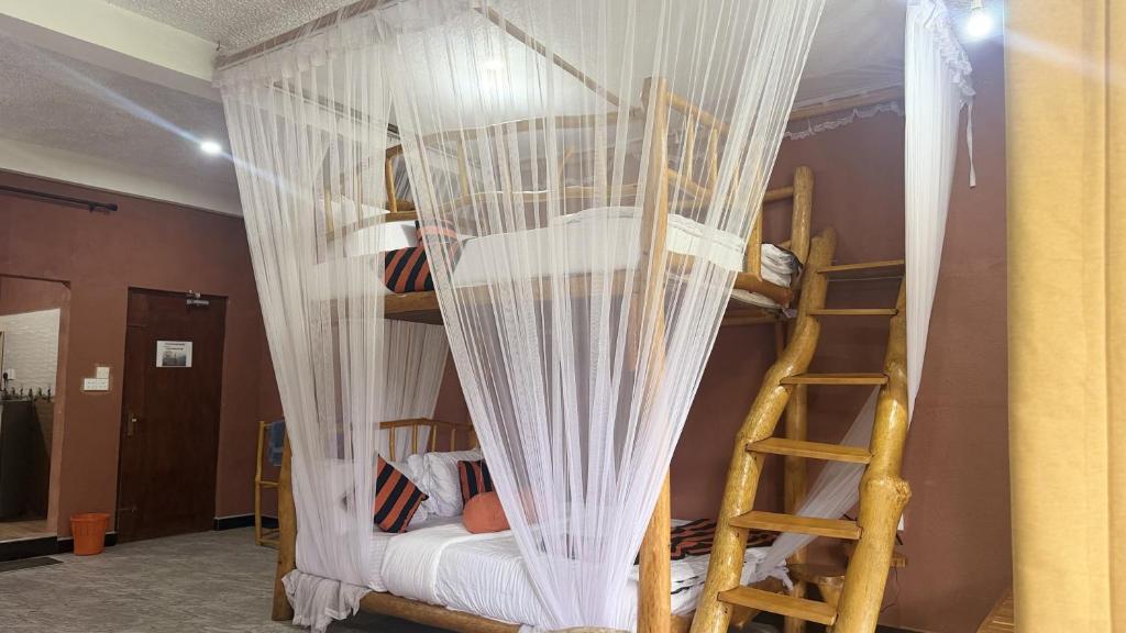 a bedroom with bunk beds with curtains and a ladder at Forest Rawana homestay Ella in Ella